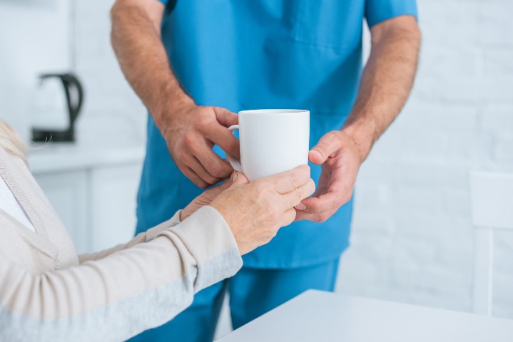 Caregiver Giving Patient Some Tea